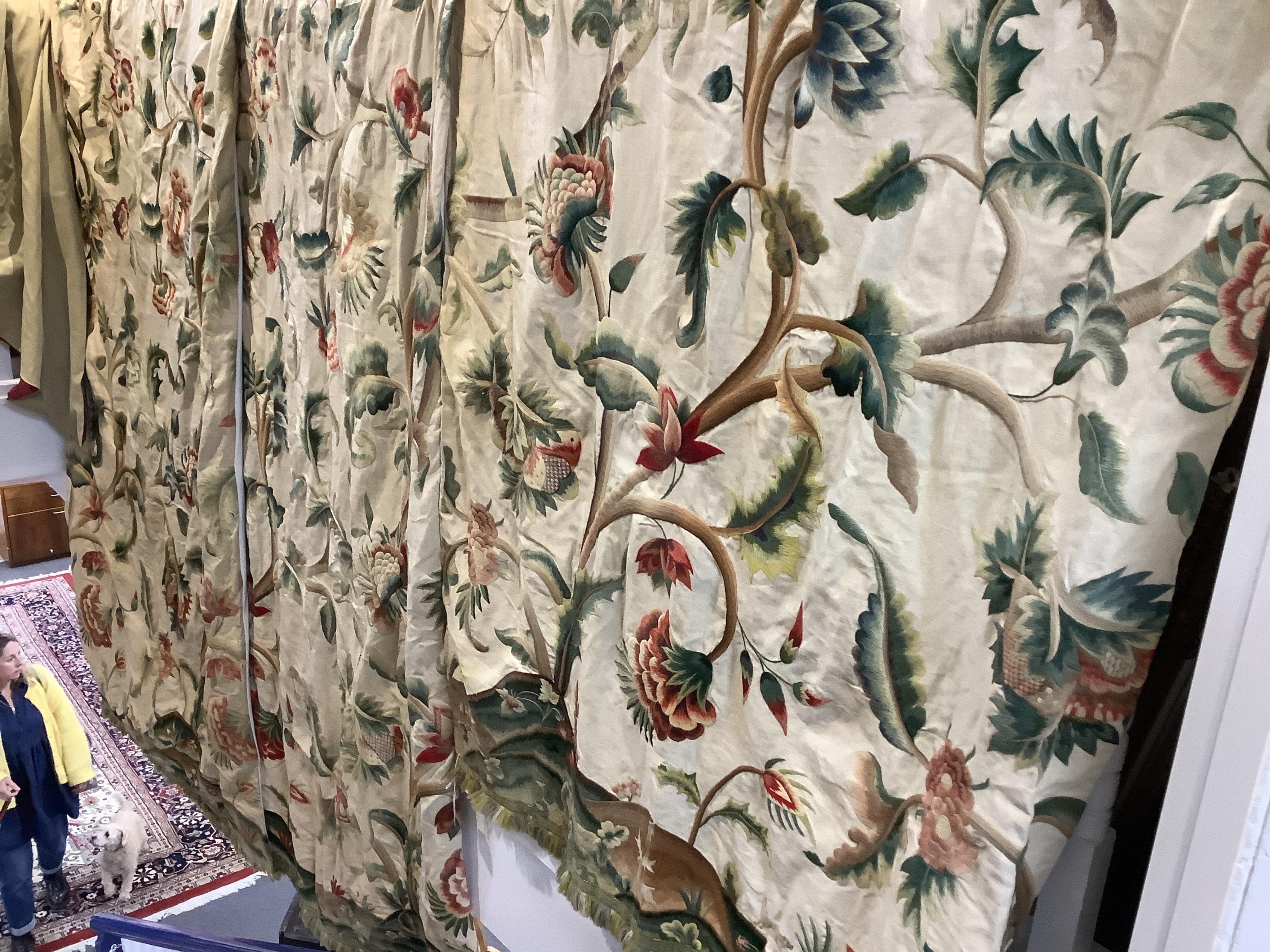 Six 20th century crewel work ‘Tree of Life’ cream linen curtains. Worked at the base in coloured wools depicting a pastoral scene of a shepherd playing a flute amongst sheep, deer, squirrels and flowers with a dog chasin